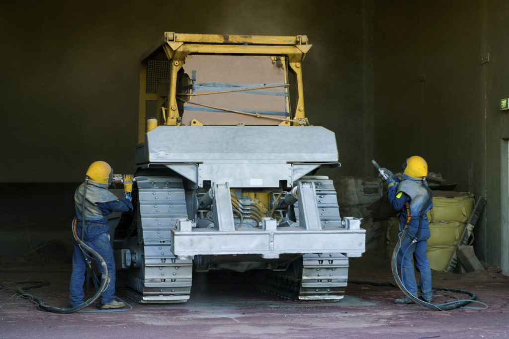 Bulldozer being sandblasted